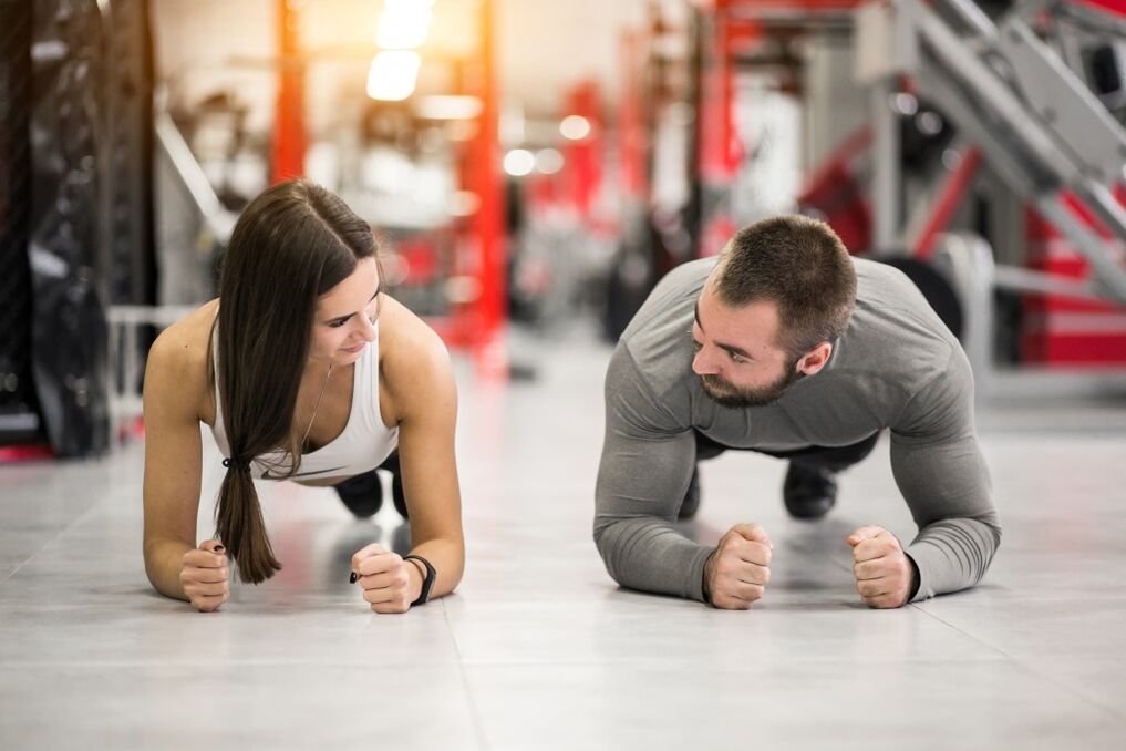 يقوم رجل وامرأة بأداء تمرين البلانك المصمم لجميع مجموعات العضلات